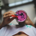 kobieta trzyma jagodowy smoothie